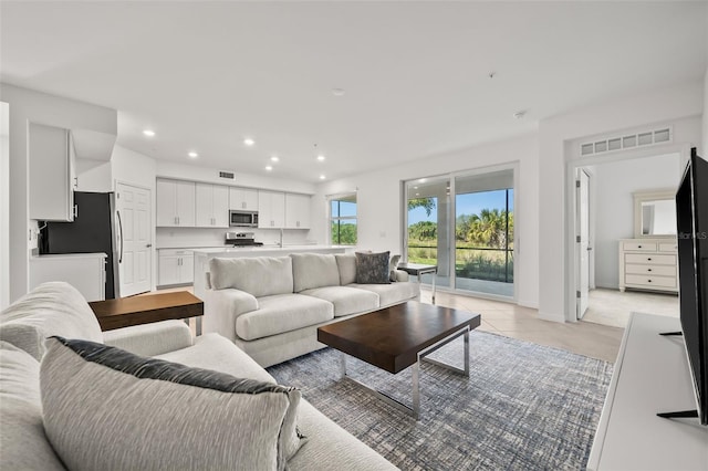 living area featuring recessed lighting, visible vents, and baseboards