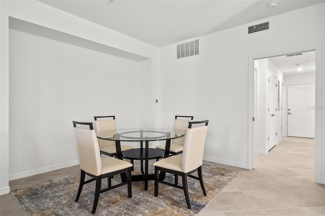 tiled dining room with baseboards and visible vents