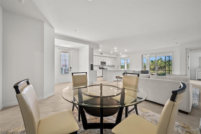 dining room featuring light tile patterned flooring, recessed lighting, baseboards, and a wealth of natural light