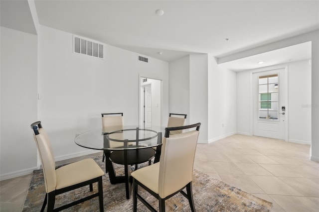 dining area featuring light tile patterned floors, visible vents, and baseboards