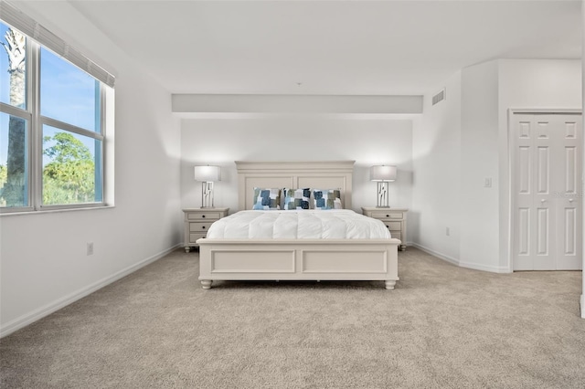 bedroom featuring visible vents, baseboards, and light colored carpet