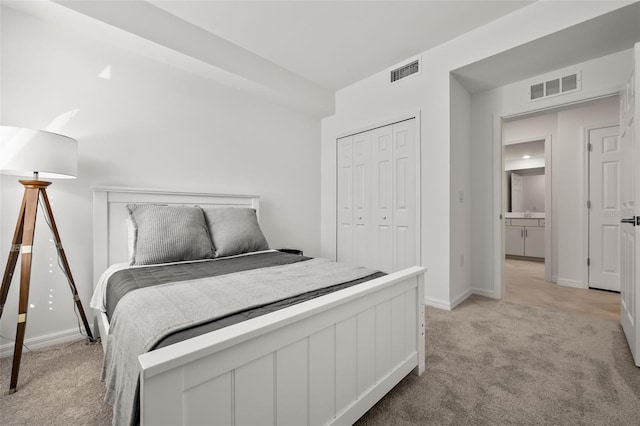 bedroom featuring visible vents, light colored carpet, and a closet