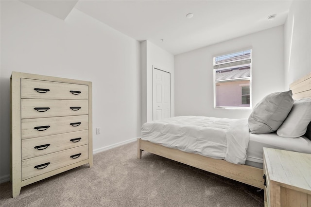 bedroom featuring light carpet, a closet, and baseboards