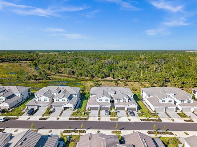 bird's eye view featuring a wooded view and a residential view