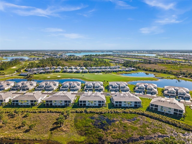 drone / aerial view featuring a residential view, golf course view, and a water view