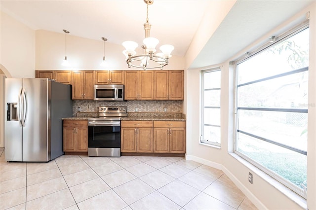 kitchen featuring vaulted ceiling, brown cabinets, backsplash, and stainless steel appliances