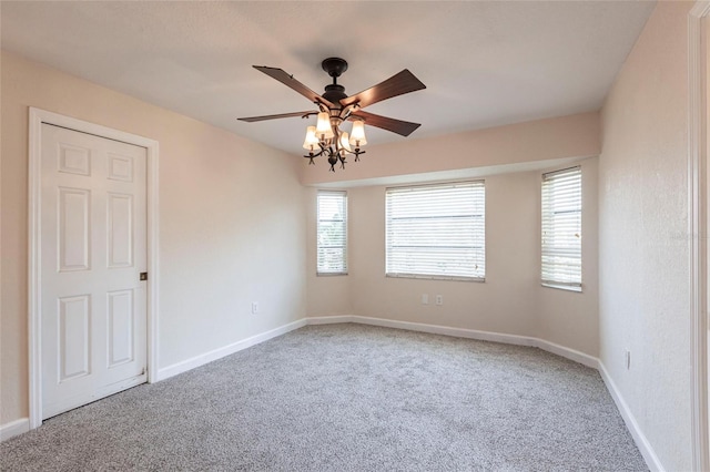 carpeted empty room with a ceiling fan and baseboards