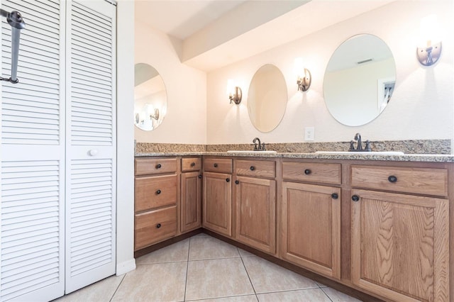 bathroom with a sink, visible vents, double vanity, and tile patterned flooring