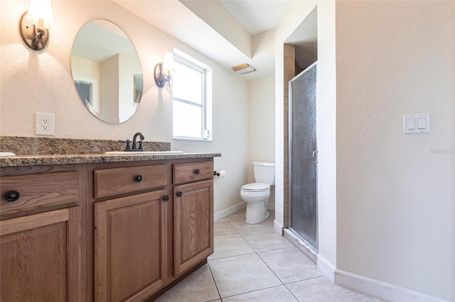 bathroom featuring tile patterned floors, a stall shower, toilet, and vanity