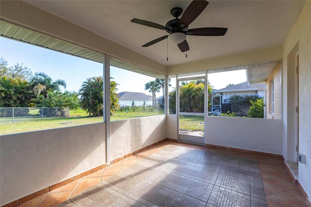 unfurnished sunroom with ceiling fan