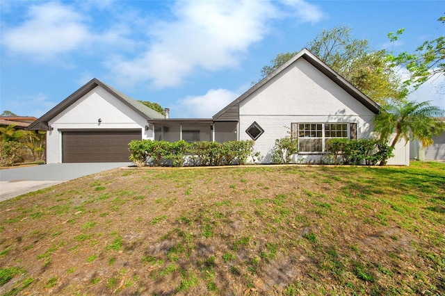 single story home with driveway, an attached garage, stucco siding, a front lawn, and brick siding