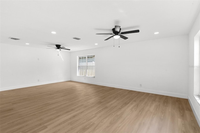 spare room featuring visible vents, recessed lighting, light wood-type flooring, and baseboards