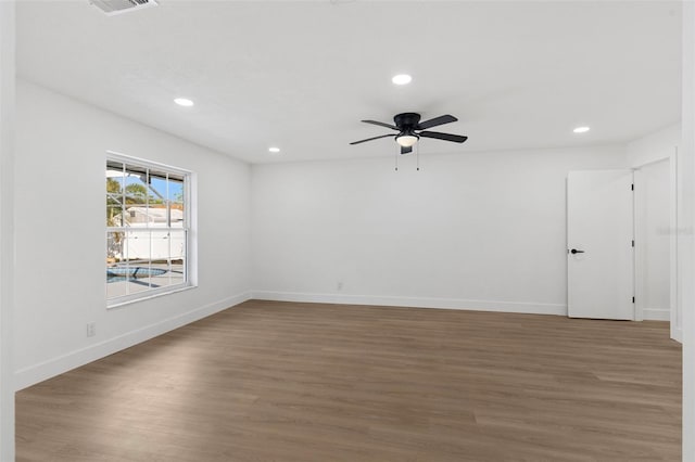 empty room featuring recessed lighting, baseboards, and wood finished floors