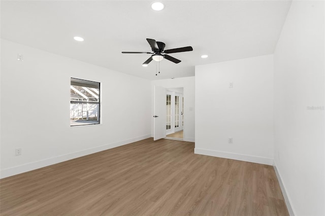 spare room featuring a ceiling fan, recessed lighting, baseboards, and light wood-type flooring