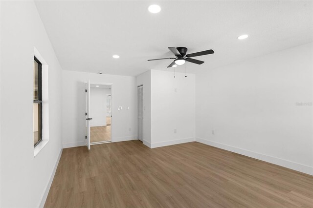 empty room featuring recessed lighting, baseboards, and light wood-style floors