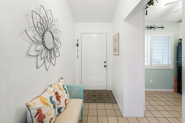 foyer entrance featuring baseboards and light tile patterned flooring