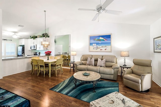 living room featuring lofted ceiling, a ceiling fan, dark wood-style flooring, and baseboards