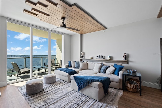 living room featuring a wall of windows, baseboards, wood finished floors, and ceiling fan