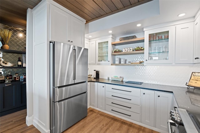 kitchen with glass insert cabinets, freestanding refrigerator, light wood-style floors, white cabinets, and open shelves