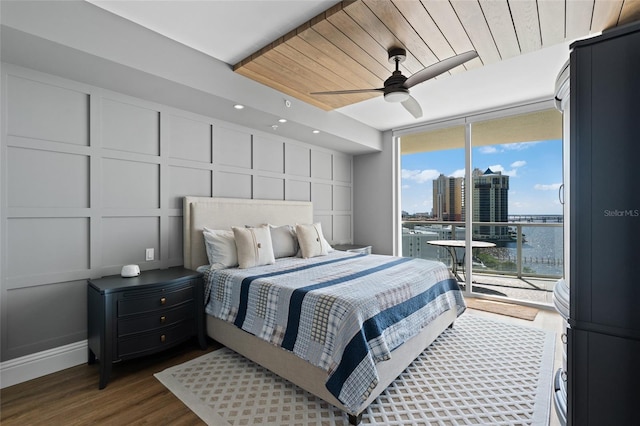 bedroom with dark wood finished floors, a decorative wall, wooden ceiling, and access to outside