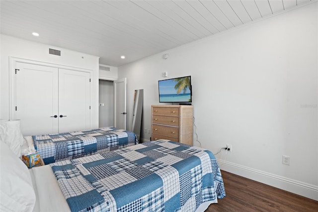 bedroom featuring visible vents, baseboards, a closet, and wood finished floors