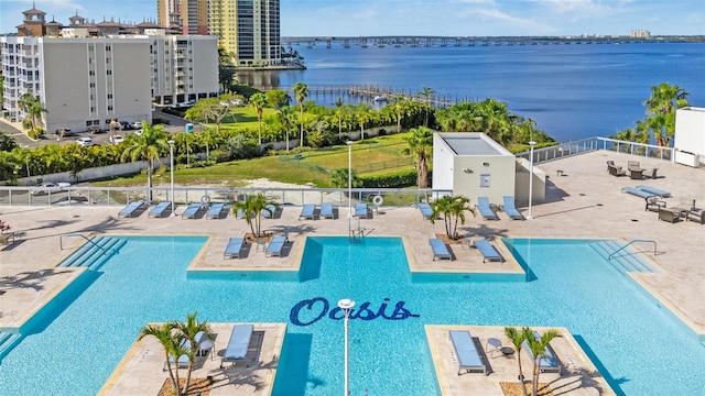 pool featuring a patio area, fence, and a water view