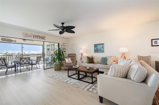 living area with wood finished floors and a ceiling fan