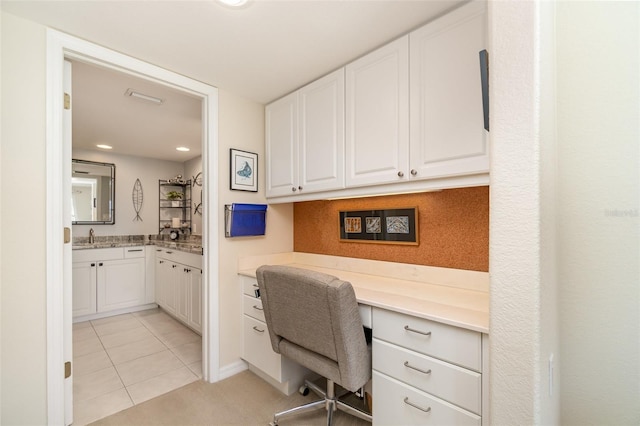 office space with light tile patterned floors and a sink