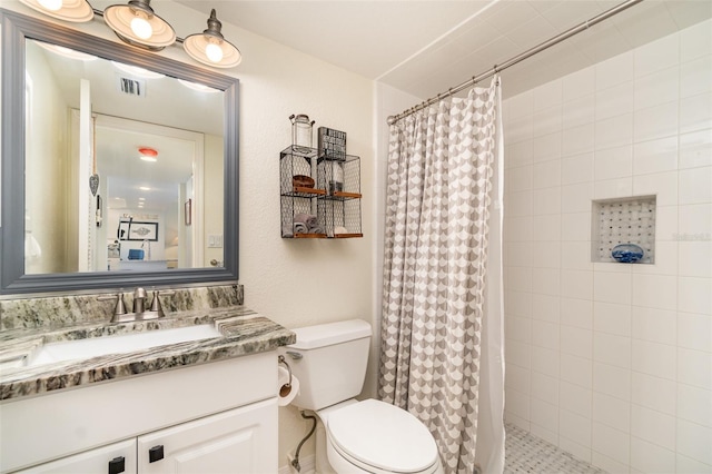 full bath featuring tiled shower, toilet, and vanity