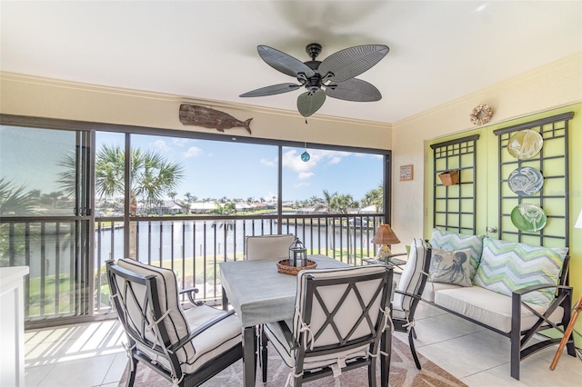 sunroom / solarium featuring a ceiling fan and a water view