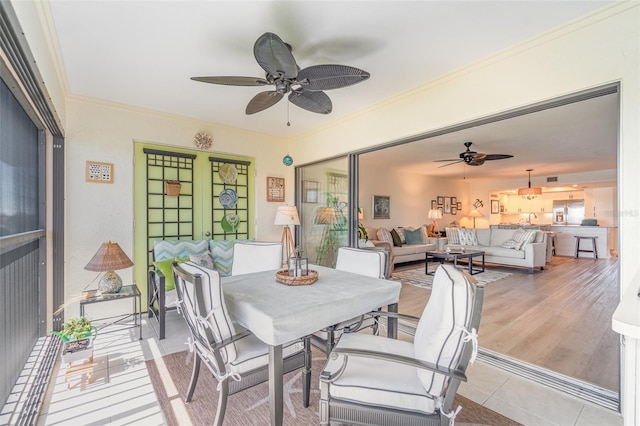 dining space featuring light wood-type flooring, crown molding, ceiling fan, and a sunroom