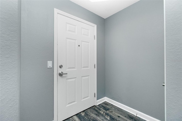 entryway with baseboards and dark wood-type flooring