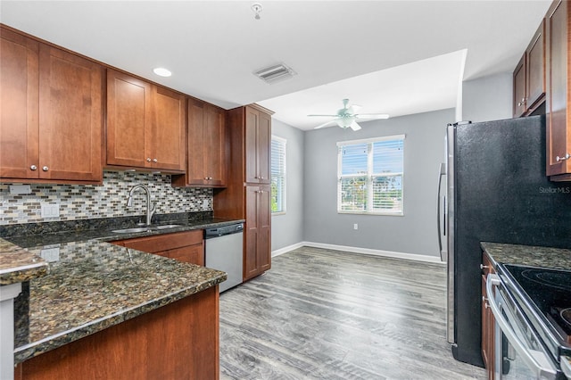 kitchen featuring light wood-type flooring, visible vents, a sink, backsplash, and stainless steel appliances