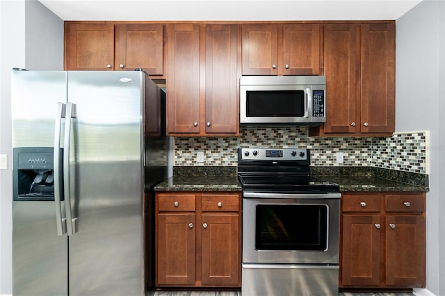 kitchen with dark stone counters, tasteful backsplash, and appliances with stainless steel finishes