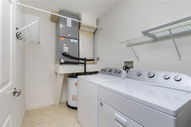 laundry room featuring washer and dryer, water heater, light tile patterned floors, baseboards, and laundry area