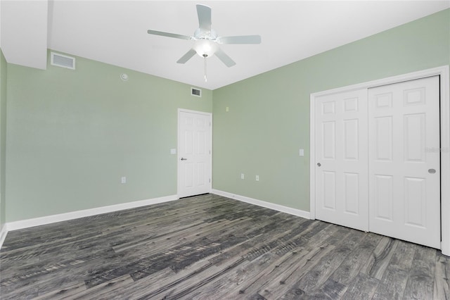 unfurnished bedroom featuring a closet, visible vents, baseboards, and wood finished floors