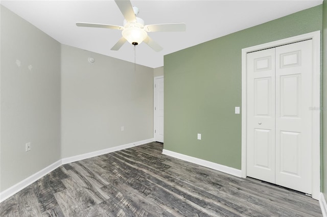 empty room featuring baseboards, wood finished floors, and a ceiling fan