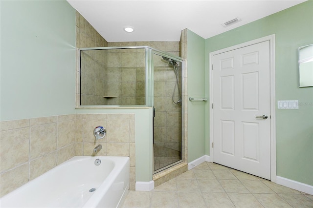 bathroom featuring tile patterned flooring, a shower stall, a bath, and baseboards