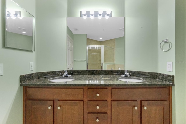 full bathroom featuring double vanity, a shower stall, and a sink