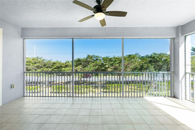 unfurnished sunroom featuring a ceiling fan