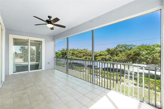 unfurnished sunroom featuring a ceiling fan