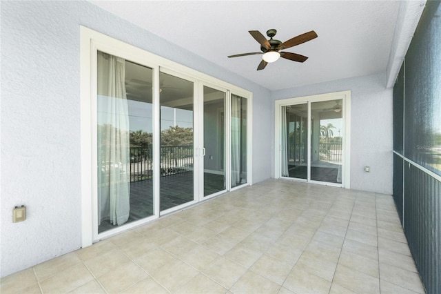 unfurnished sunroom featuring a ceiling fan