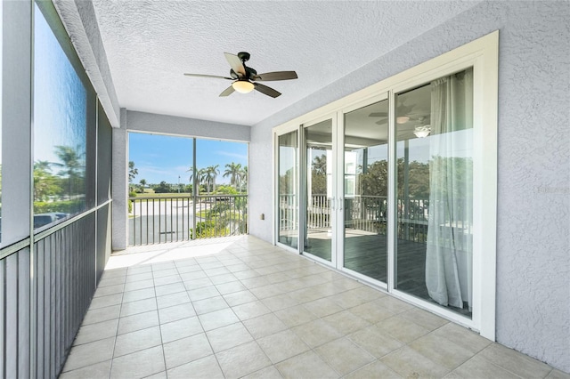 unfurnished sunroom featuring a ceiling fan