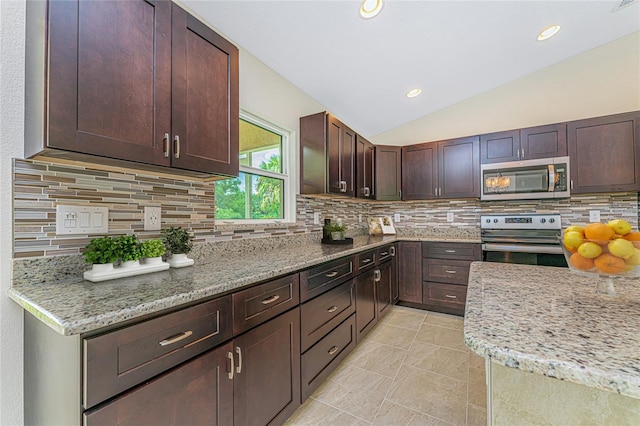 kitchen featuring tasteful backsplash, light stone countertops, dark brown cabinetry, lofted ceiling, and stainless steel appliances