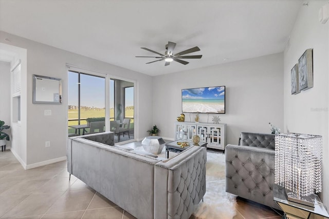 living area with light tile patterned flooring, baseboards, and a ceiling fan