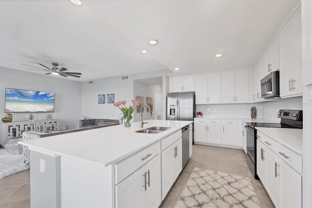 kitchen with light countertops, light tile patterned flooring, appliances with stainless steel finishes, and a sink