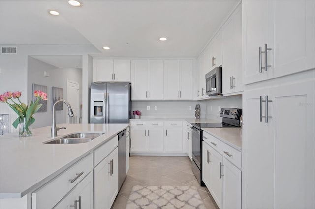 kitchen with visible vents, a sink, appliances with stainless steel finishes, white cabinets, and light countertops