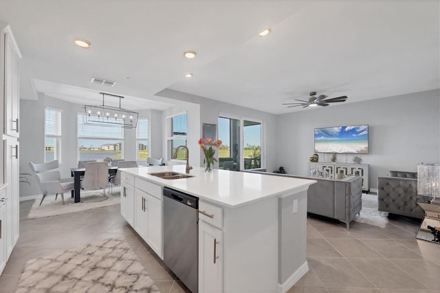 kitchen with a sink, a wealth of natural light, dishwasher, and a kitchen island with sink