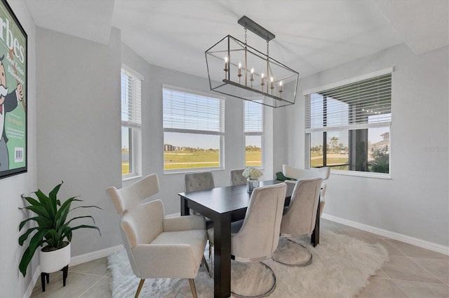 dining room featuring tile patterned flooring, a chandelier, and baseboards