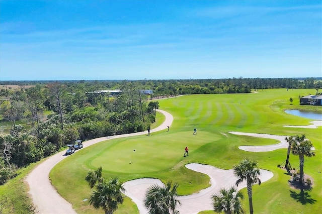 view of home's community featuring view of golf course, a forest view, and a water view